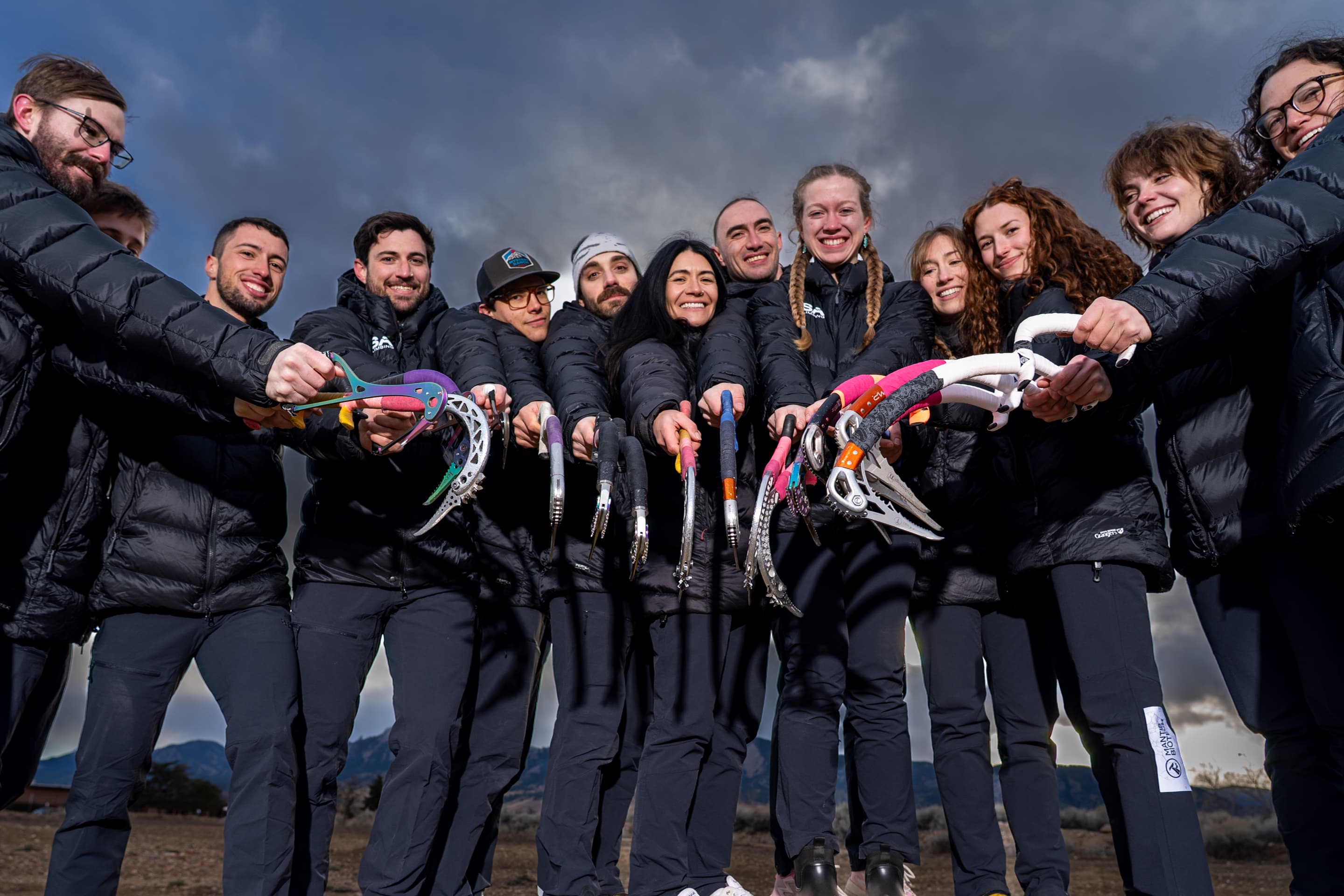 The USA Ice Climbing team holding their ice tools together in a huddle
